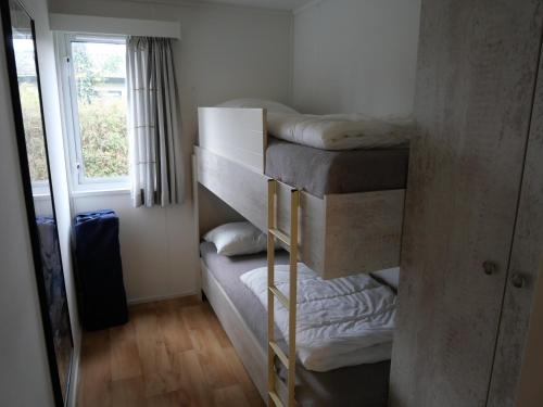 a room with three bunk beds and a window at Chalet chloë in Voorthuizen