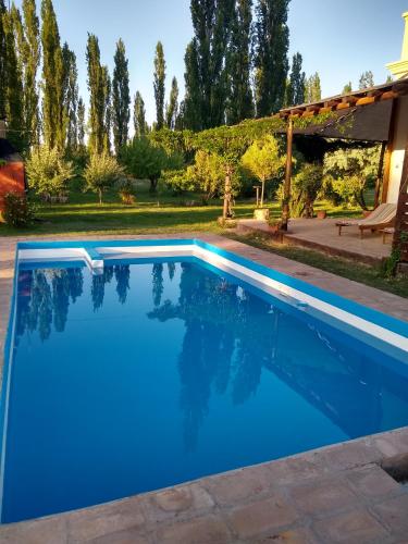 a blue swimming pool with a pergola at Finca La Penúltima-Posada in San Rafael