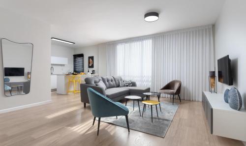 a living room with a couch and a table and chairs at Frish & Diz by HolyGuest in Tel Aviv