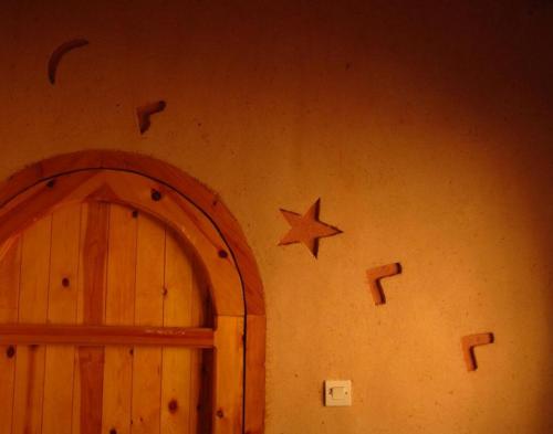 a wall with a door and a star on it at Auberge des peupliers Café Restaurant in Akhendachou nʼAït Ouffi