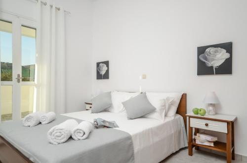 a white bedroom with a bed with towels on it at Bernie House in Mélanes