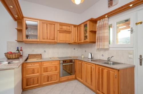 a kitchen with wooden cabinets and a sink at Bernie House in Mélanes