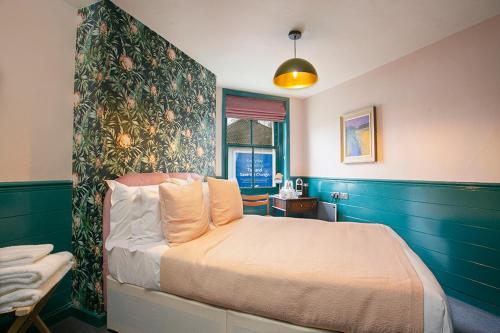 1 dormitorio con 1 cama con una pared colorida en The Ship Rooms en Londres