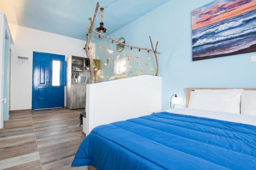 - une chambre bleue et blanche avec un lit et une porte bleue dans l'établissement Captain Elias Studios 1, à Karpathos