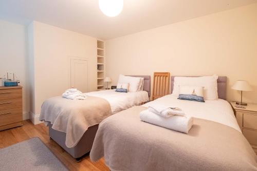 a bedroom with two beds with towels on them at Polly's - Aldeburgh Coastal Cottages in Aldeburgh
