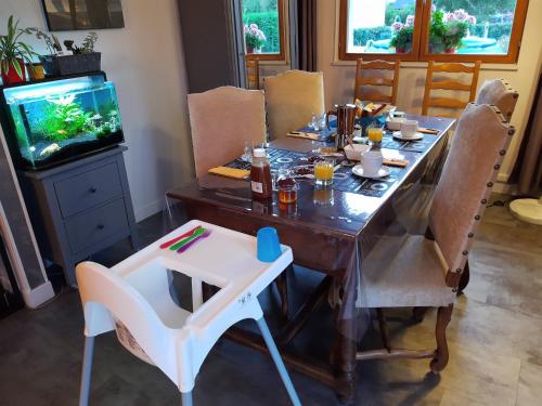 une salle à manger avec une table et un aquarium dans l'établissement La CHAMBRE, à Évran