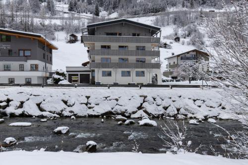 a building in the snow next to a river at Kappl Apart in Kappl