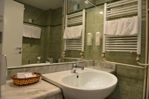 bagno con lavandino e specchio di Hotel Bellevue a Skopje