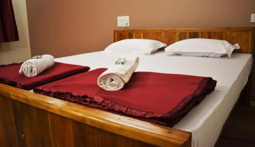 a bed with two blankets and towels on it at Viraz Valley in Gokarna