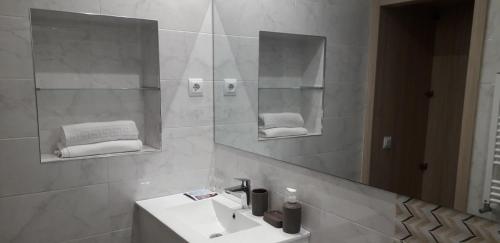 uma casa de banho com lavatório, espelho e toalhas em Ciudad de la Paz em Madri