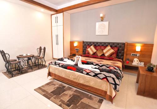 a bedroom with two beds and a table and chairs at Mayur Hotel Bar And Restaurant in Solan