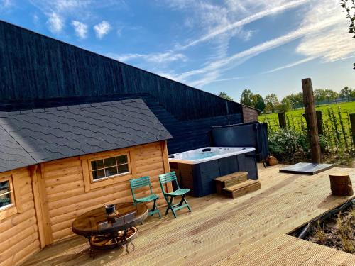 a deck with a hot tub and a table and chairs at Luxe Finse Kota van de Zandhoef in Eersel