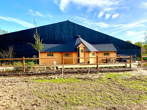 a wooden building with a fence in front of it at Luxe Finse Kota van de Zandhoef in Eersel