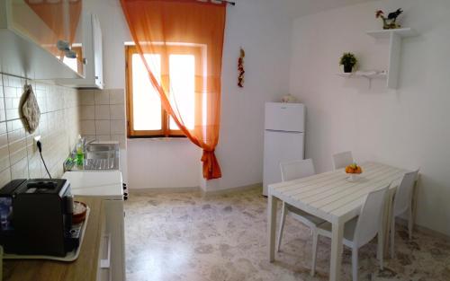 une petite cuisine avec une table blanche et une fenêtre dans l'établissement Appartamento Vela Azzurra, à Peschici