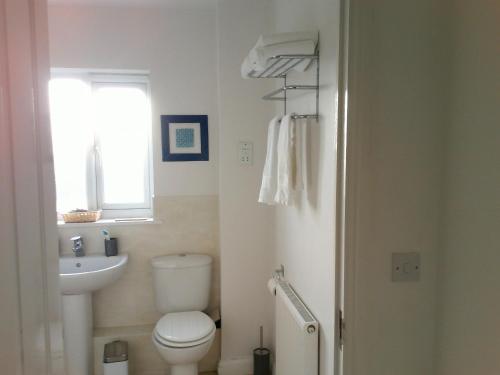 a bathroom with a toilet and a sink and a window at Two bedroom London Luxury Apartment in London