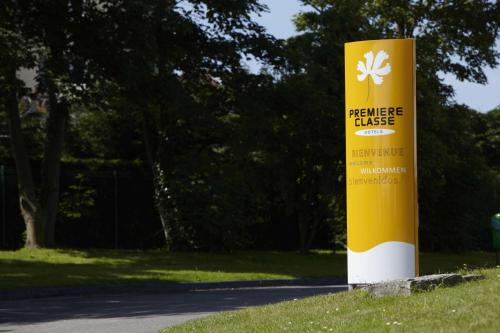 a yellow sign on the side of a road at Premiere Classe Grenoble Nord Moirans in Moirans