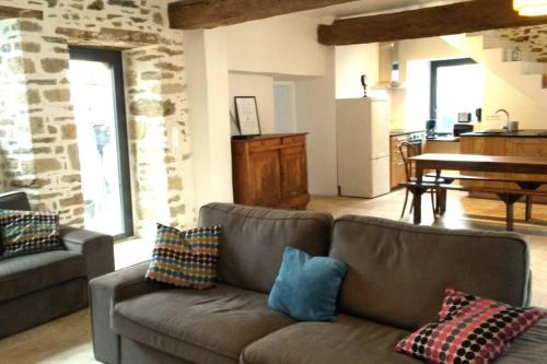 - un salon avec un canapé et des oreillers dans l'établissement KERAUDREN RHUYS - Longère XVIIIe - 10 pers - 4 chb - plage à pied, à Saint-Gildas-de-Rhuys