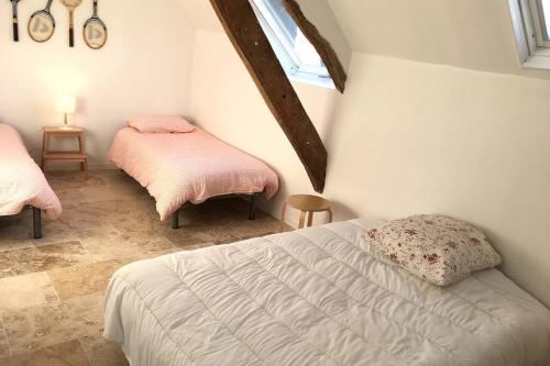 a bedroom with two beds with pink sheets and a window at KERAUDREN RHUYS - Longère XVIIIe - 10 pers - 4 chb - plage à pied in Saint-Gildas-de-Rhuys