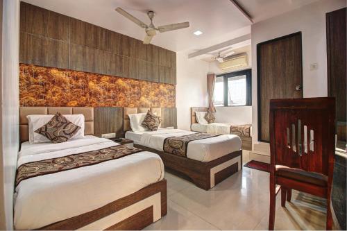 a hotel room with two beds and a window at Hotel City View in Navi Mumbai