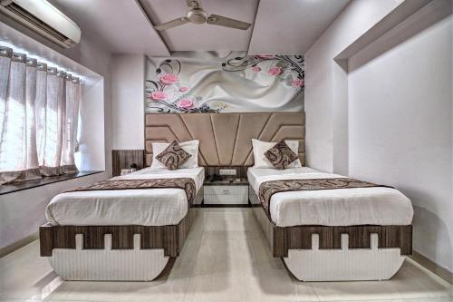 two beds in a room with white walls at Hotel City View in Navi Mumbai