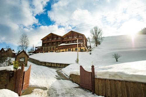 a log cabin in the snow with a fence at Georgiy in Oryavchyk