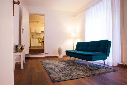 een woonkamer met een blauwe bank en een tapijt bij Casa MaMo 36 in Palermo