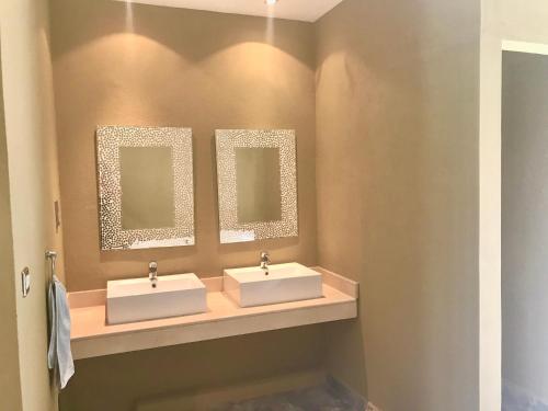 duas pias em um banheiro com dois espelhos em Bay Complex (The) em Grand Baie