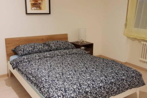 een slaapkamer met een zwart-wit dekbed op een bed bij 2.5 Rooms Furnished Family Apartment in Luzern-44 in Luzern