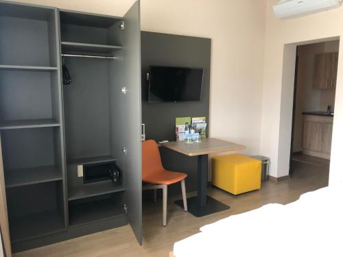 a room with a desk and a table with a chair at JUFA Hotel Graz Süd - Self Check-in in Graz