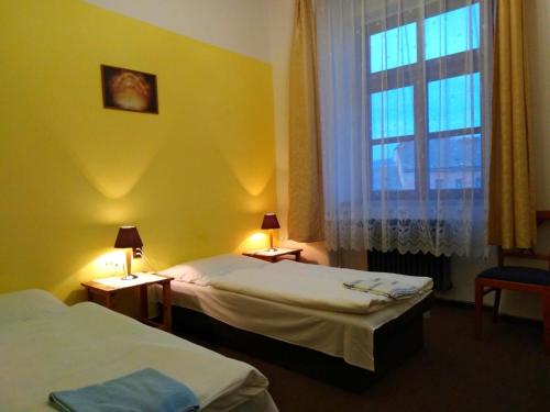 Cette chambre comprend 2 lits et une fenêtre. dans l'établissement Hotel Praded Jesenik, à Jeseník