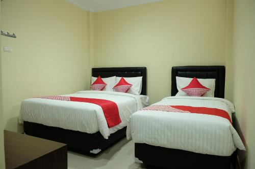 מיטה או מיטות בחדר ב-OYO 1149 Hotel Mustika