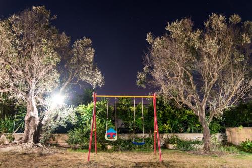 a swing in a park at night at B&B Villaggio Regina in Matino