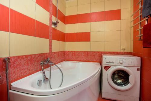 a bathroom with a tub and a washing machine at Люкс студия 1 комнатная,в центральном районе города in Mykolaiv