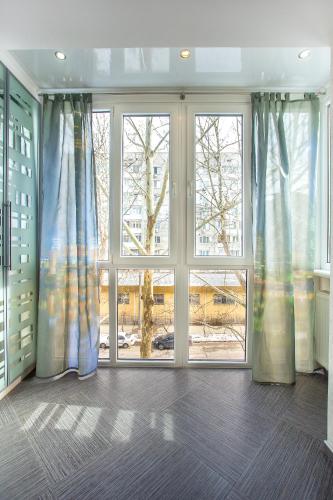 an empty room with a large window with blue curtains at Люкс студия 1 комнатная,в центральном районе города in Mykolaiv
