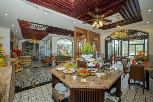 a dining room with a table with food on it at Hoang Trinh Hotel in Hoi An