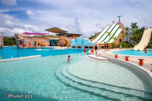 una piscina in un parco acquatico con scivolo di Zcape2 Condominium a Thalang