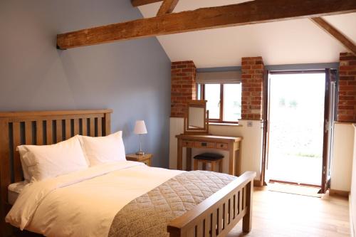 a bedroom with a bed and a window at Blashford Manor Farmhouse - New Forest Cottage in Ringwood