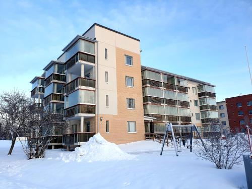 an apartment building with snow in front of it at Adorable Arctic Apartment with sauna in Rovaniemi