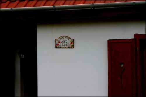 a clock on the side of a white wall at Kaláris Vendégház in Hollókő