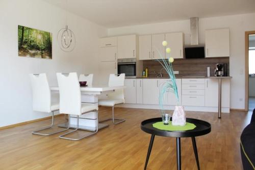 Dachterrassen Appartement Monte Lupo في فولفسبورغ: غرفة معيشة مع طاولة ومطبخ