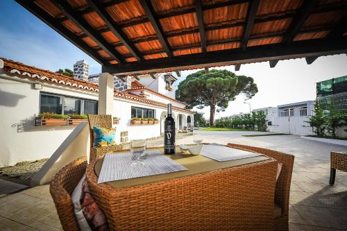 a table with a bottle of wine on a patio at Santo António's Guesthouse in Cascais