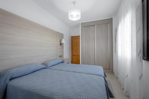 Giường trong phòng chung tại Apartamentos San Pedro