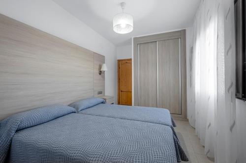 a bedroom with a blue bed in a room at Apartamentos San Pedro in Cazorla
