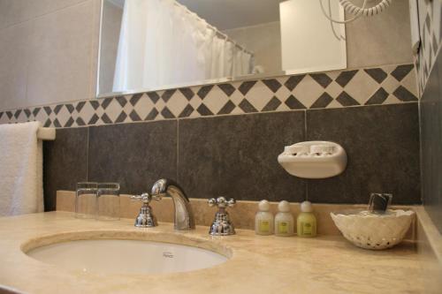 a bathroom counter with a sink and a mirror at Altos De Balcarce Hotel in Salta