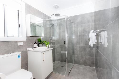 a bathroom with a shower and a toilet and a sink at Wagga Apartments #1 in Wagga Wagga