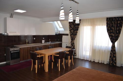 a kitchen with a wooden table and chairs at VILLA HIPODROM ilidza apartments in Sarajevo