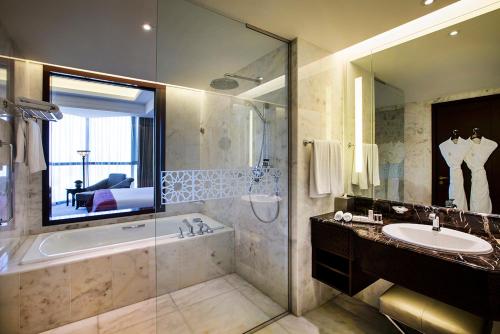 a bathroom with a tub and a sink at Bab Al Qasr Hotel in Abu Dhabi