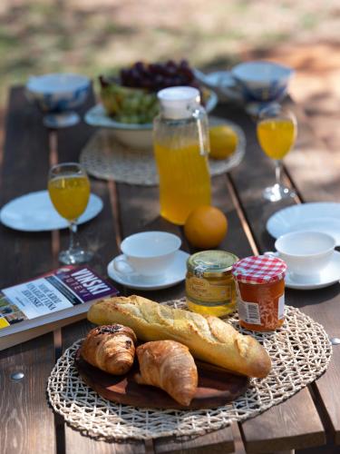 a table with a plate of bread and orange juice at Mobile Homes Camp Pineta - Adriatic Kampovi in Fažana