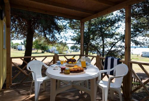 a table with a plate of food on a porch at Mobile Homes Camp Pineta - Adriatic Kampovi in Fažana