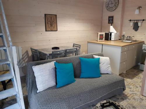 uma sala de estar com um sofá com almofadas azuis e brancas em le studio d'Oihana em Lauzun